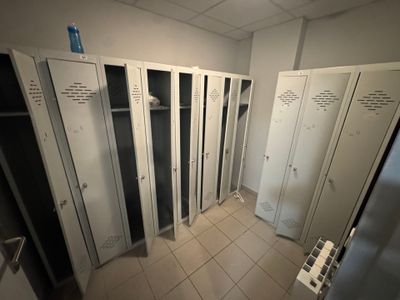 many lockers in a room with white tile flooring