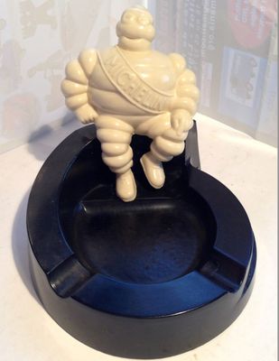 une petite statue représentant un homme assis sur un cendrier