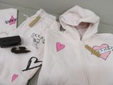 a white hoodie with pink hearts and a gun on it