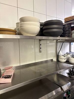 many dishes and pans on the shelves in the kitchen