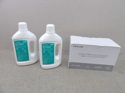 two bottles of liquid sitting on a table next to a box