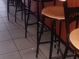 a row of wooden stools at the bar of a restaurant