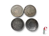 four different types of silver coins on a white surface