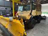 une grande déneigeuse jaune garée dans un garage