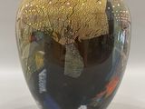 a black and gold vase sitting on a white surface