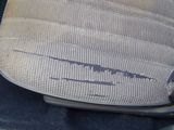 a close up of a seat in a car with a broken arm rest