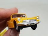 a person holding a toy car in their hand