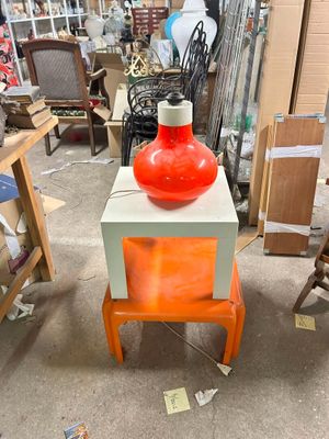 a red vase sitting on top of a table in a store