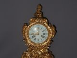 a gold clock sitting on top of a table