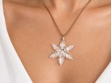 a close up of a woman wearing a white top and a necklace