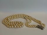 gros plan d'un collier de perles sur une surface blanche