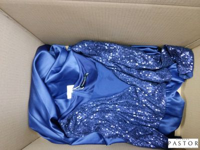 une chemise bleue dans une boîte en carton sur laquelle est accrochée une étiquette