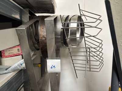 une photo d'une cuisine où de nombreuses casseroles et poêles sont suspendues au mur