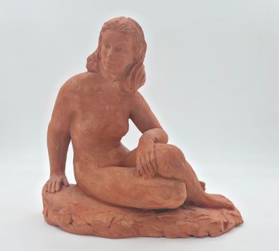 statue d'une femme assise sur un rocher, sur fond blanc