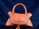 un sac à main en cuir orange sur fond bleu
