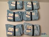 six paires de jeans bleus sont empilées sur une table