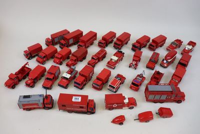 beaucoup de petits camions rouges en plastique posés sur une table