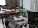 a desk with a computer and a lot of books on it