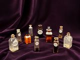 plusieurs petites bouteilles d'alcool posées sur un tissu violet