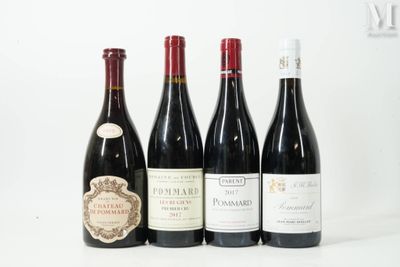 quatre bouteilles de vin sont alignées sur une surface blanche