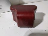 a brown leather camera case sitting on a white counter