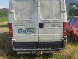 une camionnette garée dans un champ à côté d'une voiture rouge
