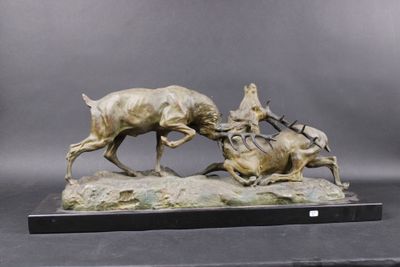 bronze sculpture of a dog chasing a deer on a rock