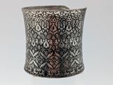 a close up of a silver cuff with an intricate design on it
