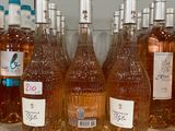bottles of wine are lined up on a shelf in a kitchen