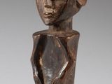 un gros plan sur une statue en bois représentant une personne portant un chapeau