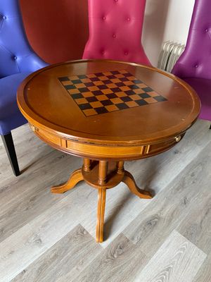trois chaises placées à côté d'une table sur laquelle se trouve un échiquier
