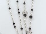 a close up of a rosary with black and white beads