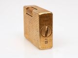 an image of a gold lighter sitting on top of a white surface