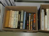 une boîte remplie de livres posée par terre près d'une fenêtre