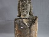 une statue de femme assise au sommet d'un rocher
