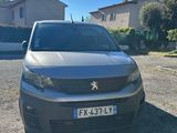 une voiture grise garée sur un parking à côté d'une maison