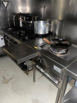 une cuisinière sur laquelle sont posées des casseroles et des poêles, dans une cuisine