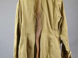 an old jacket is hanging on a wooden stand on a gray background