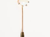 une broche dorée et blanche ornée d'une fleur