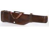 an old leather guitar case sitting on top of a white surface
