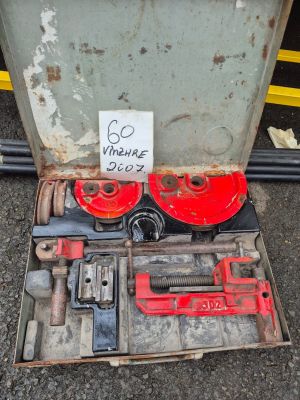 une boîte à outils posée par terre à côté d'une boîte sur laquelle est accrochée une pancarte