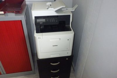 une imprimante posée sur une armoire dans une pièce