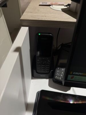 un téléphone portable posé sur un bureau, à côté d'un écran