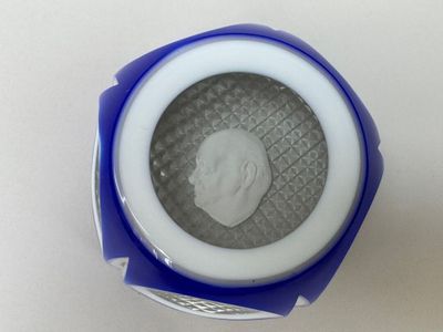 un gros plan d'un objet bleu et blanc contenant une pièce de monnaie