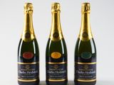 three bottles of champagne are lined up against a white background