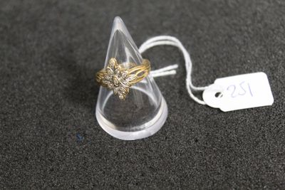 une bague en or posée sur un cône transparent, avec une étiquette de prix