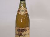 an old bottle of wine sitting on top of a white table