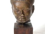 statue of a head on a wooden block on a white background