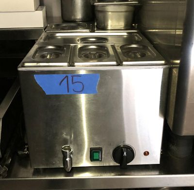 un plan de travail en acier inoxydable sur lequel sont posés des casseroles et des poêles