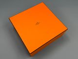 un gros plan d'une boîte orange posée sur une surface grise